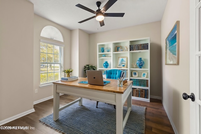 office area with dark wood-type flooring, a ceiling fan, and baseboards