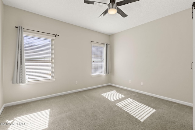 spare room featuring a textured ceiling, baseboards, a ceiling fan, and carpet floors