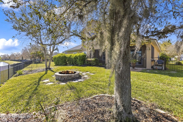 view of yard featuring a fenced backyard and a fire pit