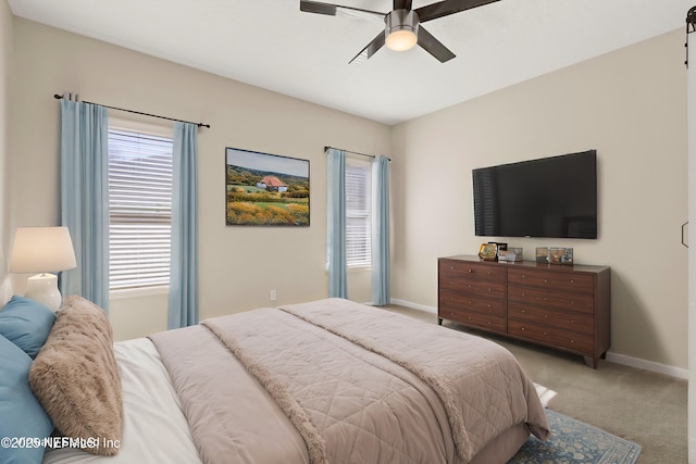 bedroom featuring baseboards, light colored carpet, and a ceiling fan