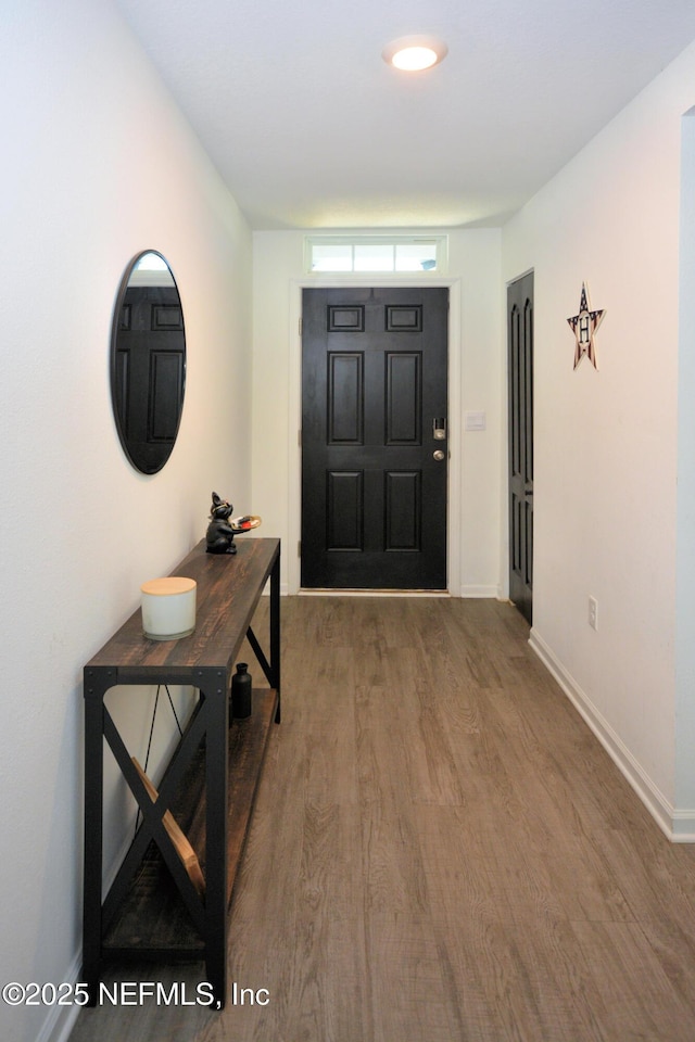 foyer entrance featuring baseboards and wood finished floors