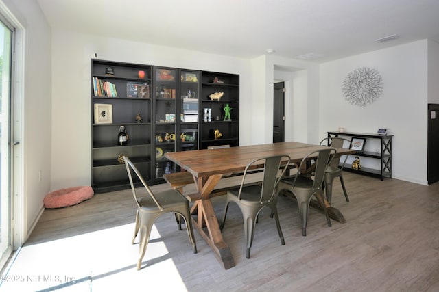 dining area featuring light wood finished floors and visible vents