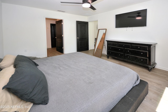 bedroom with visible vents, ceiling fan, baseboards, and wood finished floors