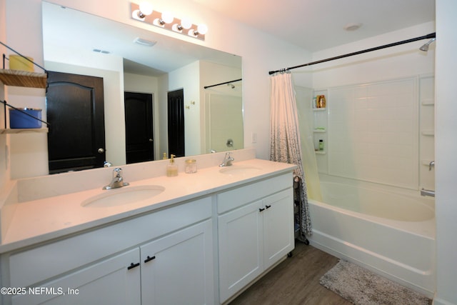 bathroom featuring shower / tub combo with curtain, visible vents, a sink, and wood finished floors