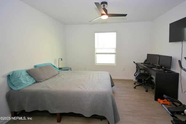 bedroom with wood finished floors, a ceiling fan, and baseboards