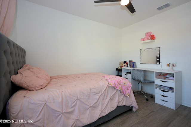 bedroom featuring ceiling fan, visible vents, and wood finished floors