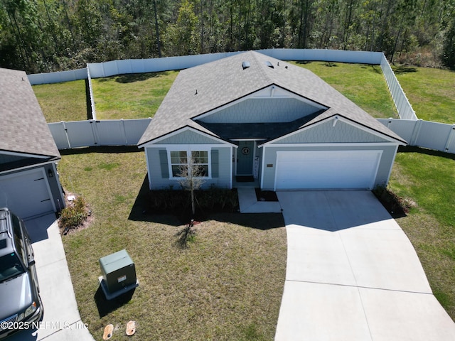 view of front of house featuring a fenced backyard, concrete driveway, and a front yard