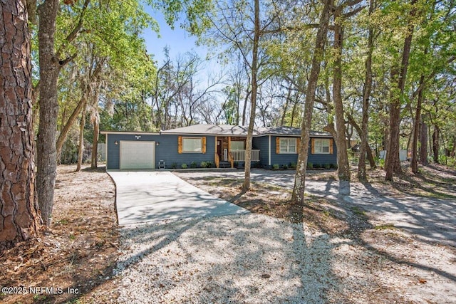 view of front of house with driveway, a porch, and an attached garage