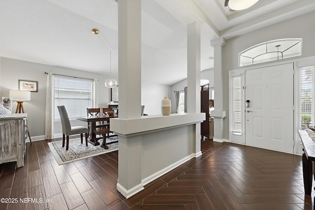 foyer entrance featuring an inviting chandelier, parquet flooring, and baseboards