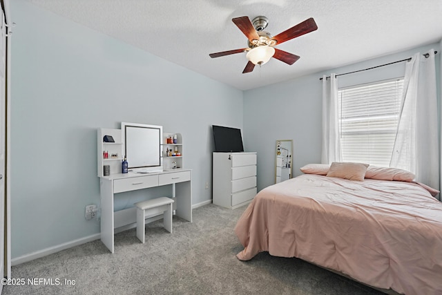 bedroom featuring light carpet, ceiling fan, a textured ceiling, and baseboards