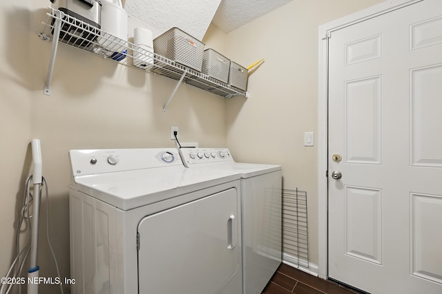 washroom with dark wood-type flooring, washer and dryer, laundry area, and a textured ceiling