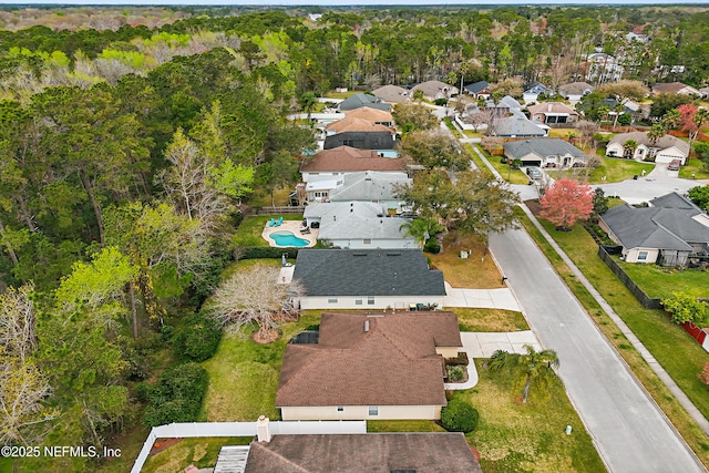 birds eye view of property featuring a residential view and a wooded view