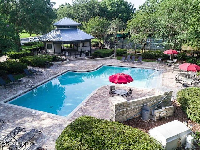 pool with a patio area, fence, and a gazebo