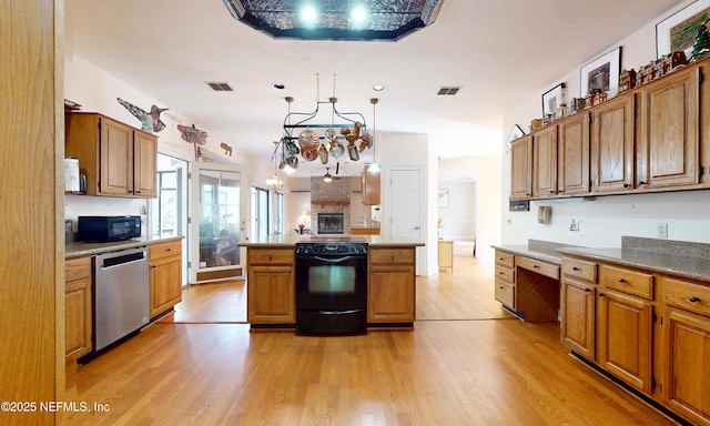 kitchen with brown cabinetry, visible vents, light wood finished floors, and black appliances