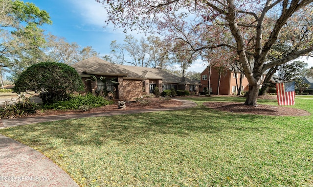 view of front of house featuring a front yard and brick siding