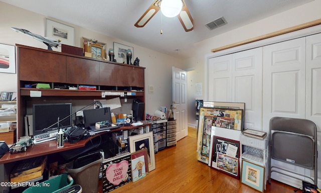 office featuring a ceiling fan, visible vents, and wood finished floors