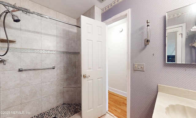 bathroom featuring a tile shower and wood finished floors