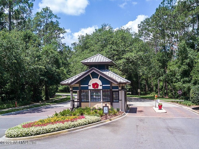 exterior space featuring curbs and a gated entry