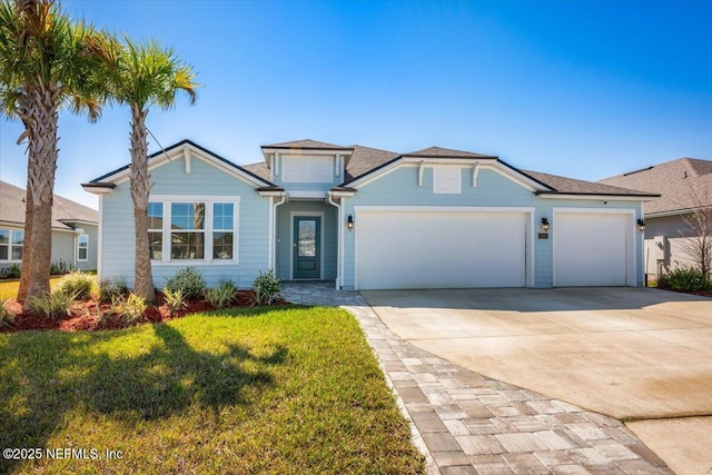 view of front of property with a front lawn, an attached garage, and driveway