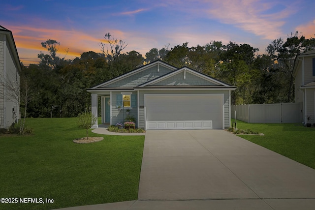 ranch-style home with a garage, driveway, a front yard, and fence