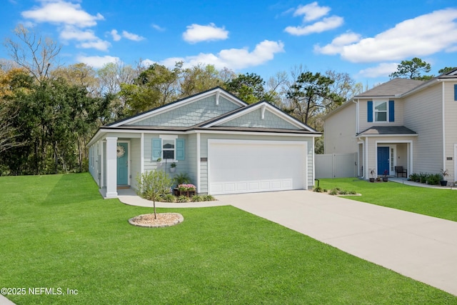 view of front facade featuring an attached garage, fence, concrete driveway, and a front yard