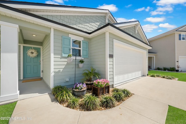 entrance to property featuring driveway and an attached garage