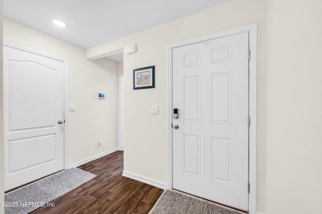 foyer entrance featuring dark wood finished floors and baseboards