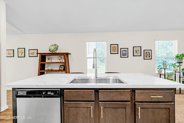 kitchen featuring light stone counters, a sink, light wood-style floors, dark brown cabinets, and stainless steel dishwasher