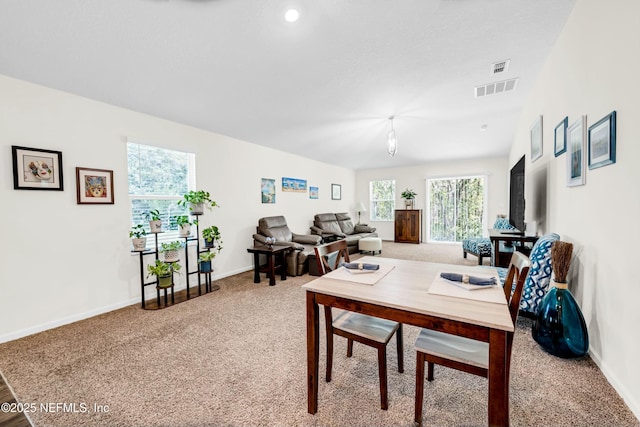 dining room featuring carpet floors, visible vents, and baseboards