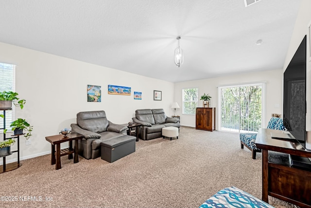 living area with carpet, baseboards, and a textured ceiling