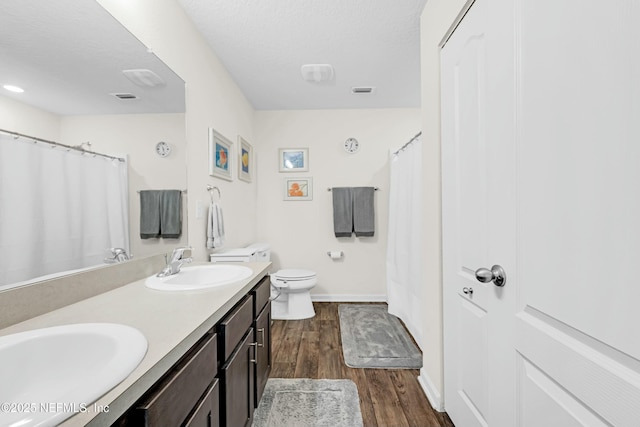 full bath with visible vents, a sink, toilet, and wood finished floors