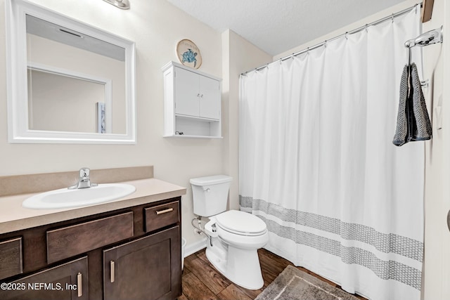 bathroom with toilet, a textured ceiling, vanity, wood finished floors, and a shower with curtain