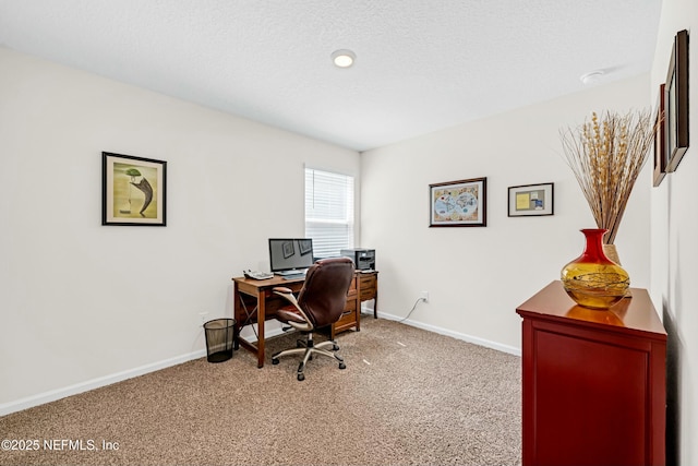 carpeted office space with a textured ceiling and baseboards