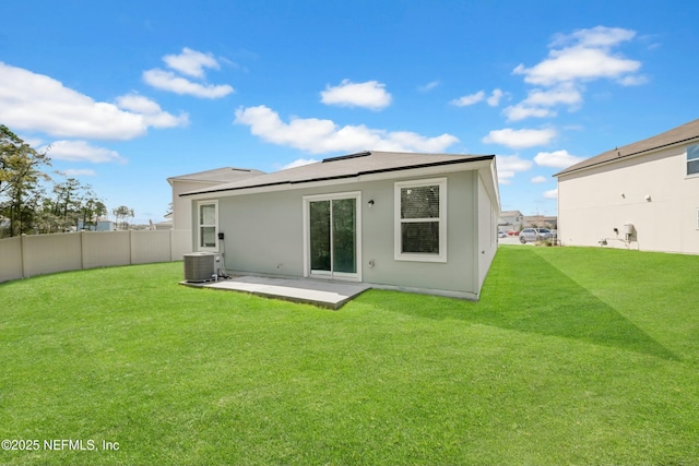 back of house featuring a patio area, central AC, fence, and a lawn