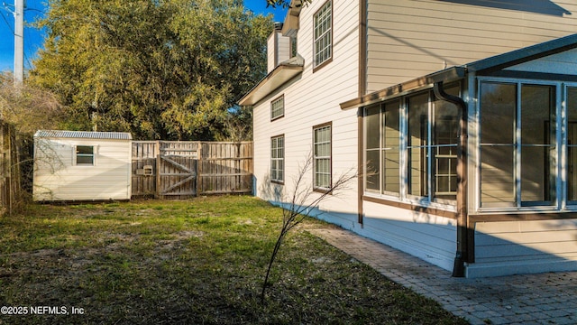 view of property exterior featuring an outdoor structure, fence, a lawn, a gate, and a chimney