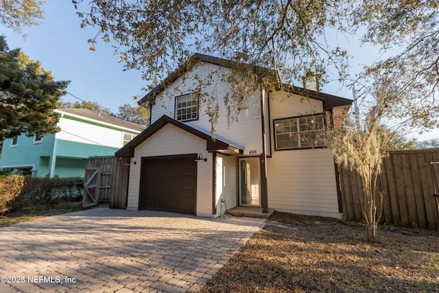 view of front of house with fence and decorative driveway