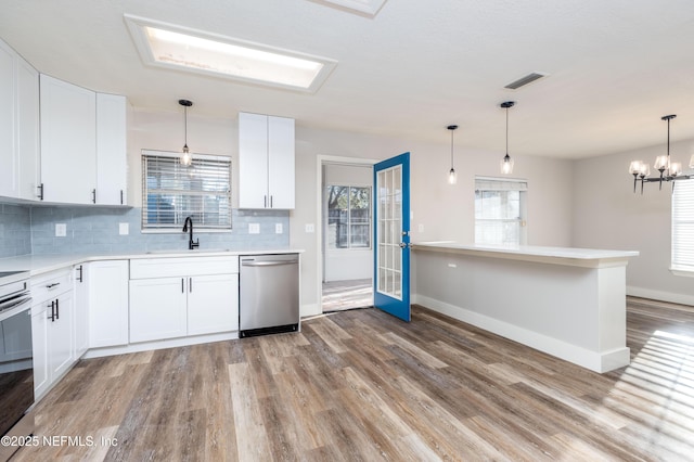 kitchen featuring a sink, white cabinetry, visible vents, and stainless steel dishwasher