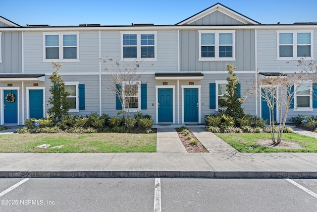 view of property with uncovered parking and board and batten siding