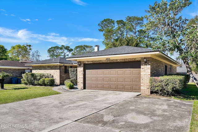 view of front of house with a front yard, brick siding, concrete driveway, and an attached garage