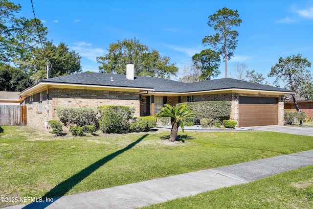 view of front of property featuring brick siding, a front yard, a chimney, driveway, and an attached garage