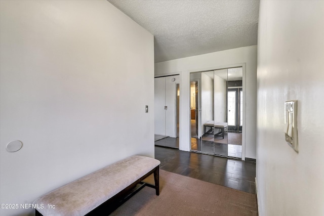 hallway with hardwood / wood-style flooring and a textured ceiling