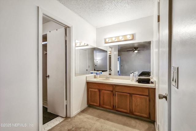 bathroom with vanity, ceiling fan, and a textured ceiling