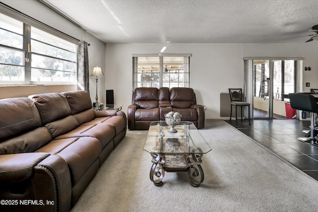 tiled living area featuring a textured ceiling and a ceiling fan