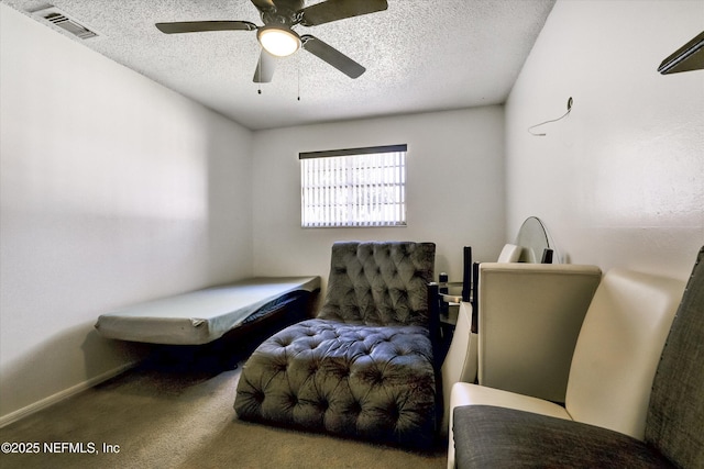 sitting room with visible vents, a textured ceiling, and carpet