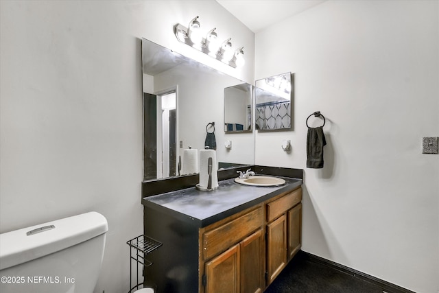 half bath featuring vanity, toilet, and baseboards