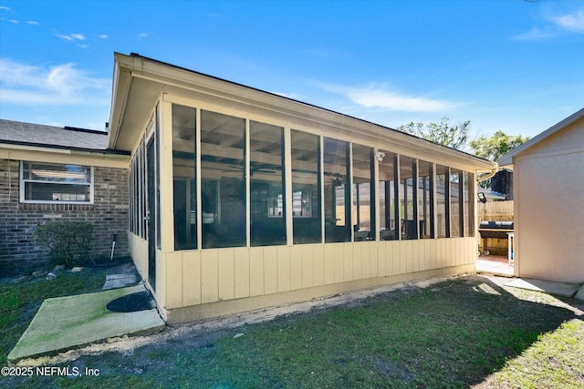 view of property exterior with brick siding and a sunroom