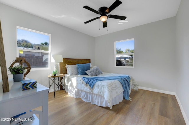 bedroom featuring ceiling fan, baseboards, and wood finished floors