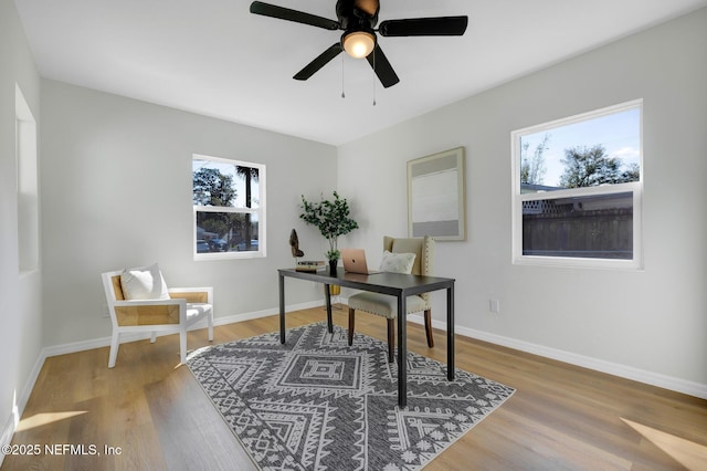 home office featuring baseboards, a wealth of natural light, and light wood-style floors