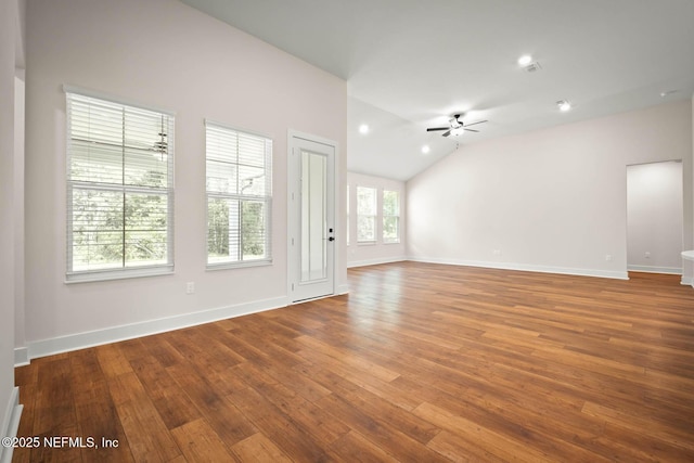 spare room with a ceiling fan, lofted ceiling, baseboards, and wood finished floors