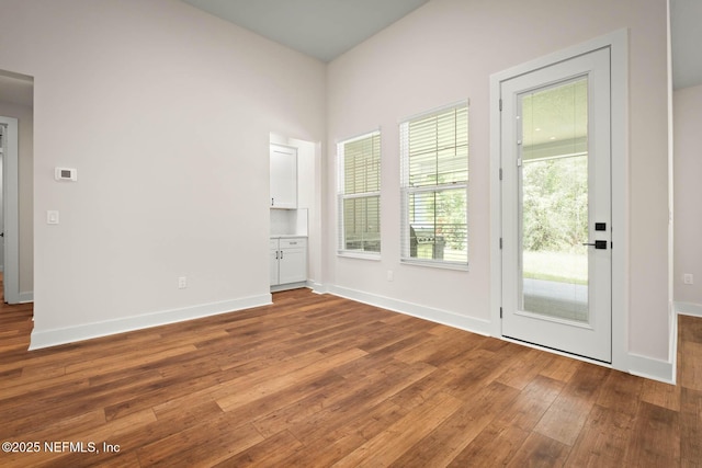 empty room featuring baseboards and hardwood / wood-style floors